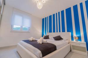 a bedroom with a bed with blue and white stripes at Lux Apartments in Makarska