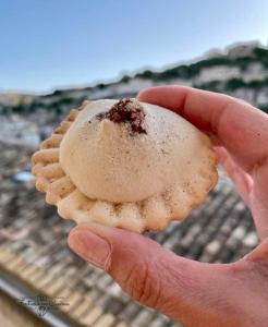 a person holding a piece of food in their hand at A casa di Carmen in Modica +19 photos