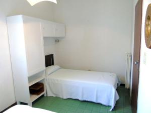 a small bedroom with a white bed and a cabinet at Viletta Pioppi in Lido delle Nazioni