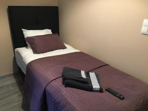 a bedroom with a bed with a remote control on it at Rooms Banjac in Maribor
