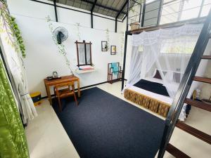 a room with a bed and a desk in it at Mountain Breeze Villa & Ayurveda Spa in Ella