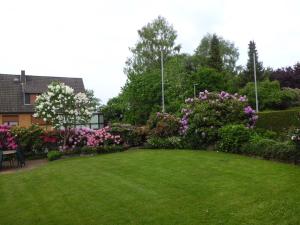 einen Garten mit rosa und weißen Blumen und Büschen in der Unterkunft Haus Wiesel in Bispingen