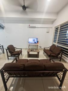 a living room with a couch and chairs and a tv at JN Villa Homestay 5 Bedroom house, Near Airport Kota Kinabalu in Donggongon