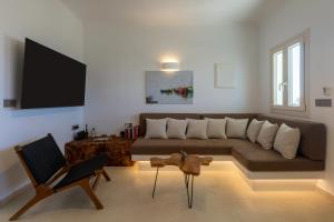 a living room with a couch and a tv at Villa Karras - Sea & Mountain View in Perissa