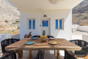 a dining room with a wooden table and chairs at Villa Karras - Sea & Mountain View in Perissa