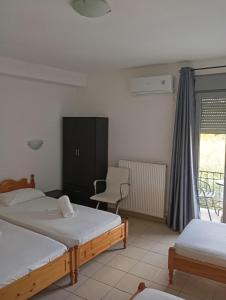 a bedroom with two beds and a chair and a window at Pyrgos Sofokleous in Mytilene