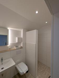 a white bathroom with a toilet and a sink at Hotel zur Erholung in Buxtehude +32 photos