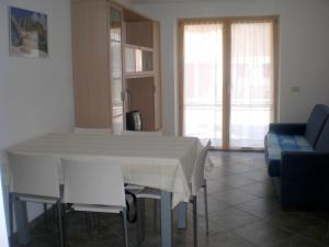 uma sala de estar com uma mesa branca e cadeiras em Anna Apartment em Pozza di Fassa