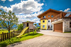 a playground with a slide in front of a house at Bauernhof Unterbichl in Flachau