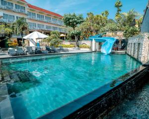a swimming pool with a slide in a resort at The Tanis Beach Resort Nusa Lembongan in Nusa Lembongan
