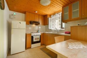 a kitchen with a white refrigerator and a table at Studio Liana in Frikes