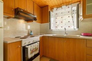 a kitchen with a stove and a sink and a window at Studio Liana in Frikes +17 photos