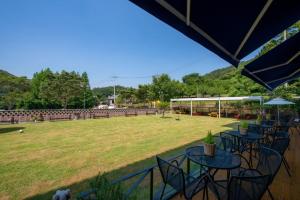 a group of tables and chairs in a field at Suncheon raon house egyeon pension in Suncheon