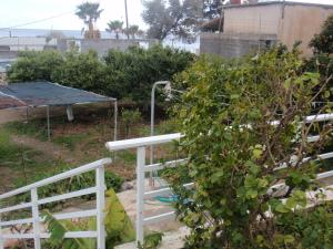 un jardin avec une clôture blanche et une brousse dans l'établissement Antouan Matina, à Archangelos