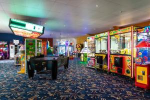 a room with several arcade games and a pool table at PMH rental in Saint Osyth