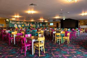 a dining room filled with tables and colorful chairs at PMH rental in Saint Osyth