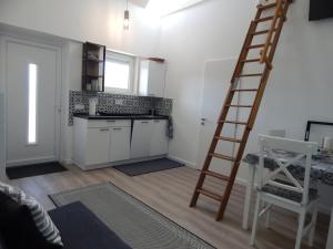 a kitchen with a ladder in the middle of a room at JundJ Ferienwohnungen in Buzsák