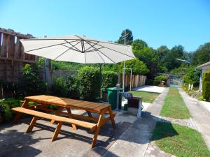 a picnic table and an umbrella in a backyard at JundJ Ferienwohnungen in Buzsák