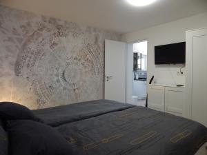 a bedroom with a bed and a tv on a wall at JundJ Ferienwohnungen in Buzsák