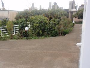 a driveway with a white fence and some bushes at Antouan Matina in Archangelos