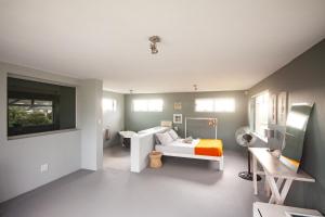 a room with a bed and a desk in it at Betty's Bay Cottage in Bettyʼs Bay