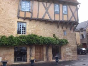 een oud gebouw met planten aan de zijkant bij Villa La Roseraie avec accès piscine Hôtel La Roseraie in Montignac