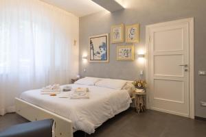 a bedroom with a bed with white sheets and a window at Villa Atusca - Castiglioncello in Castiglioncello