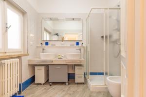 a bathroom with two sinks and a shower at Villa Atusca - Castiglioncello in Castiglioncello +35 photos