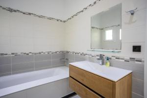 a bathroom with a tub and a sink and a mirror at Mario's Kassiopi in Kassiopi +19 photos