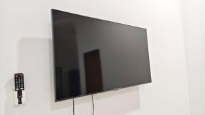 a flat screen tv on a white wall at UMRA Homestay in Kampong Padang Kemunting