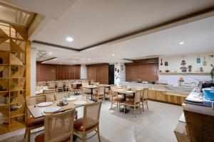 a restaurant with tables and chairs and a kitchen at Monday Hotels Hitec City in Hyderabad +36 photos