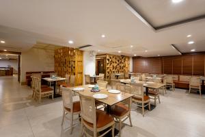 a restaurant with tables and chairs in a room at Monday Hotels Hitec City in Hyderabad