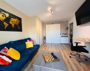 a living room with a blue couch and a chess board at Studio de vacances Stella Plage in Cucq +5 photos