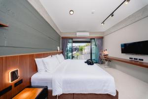 ein Schlafzimmer mit einem großen weißen Bett und einem Fernseher in der Unterkunft MEE DEE Hostel in Ao Nang Beach