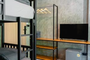 Ein Schlafzimmer mit einem Etagenbett und einem Fernseher auf einem Regal. in der Unterkunft MEE DEE Hostel in Ao Nang Beach + 22 Fotos