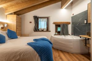 a bedroom with a large bed and a bath tub at Rifugio del Firenze Ninfa in Sestola