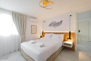 a bedroom with a large white bed with towels on it at Kismet Urban Boutique in Heraklio +79 photos