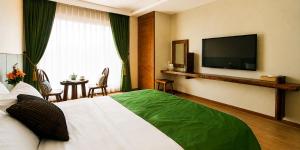 ein Hotelzimmer mit Bett und Flachbildfernseher in der Unterkunft Login Hotel in Jeju-do