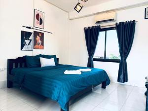 a bedroom with a blue bed and a window at Santara Hostel in Vang Vieng