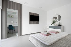 a white bedroom with a bed and a mirror at Bella Casa - piso inferior in Angra do Heroísmo +20 photos