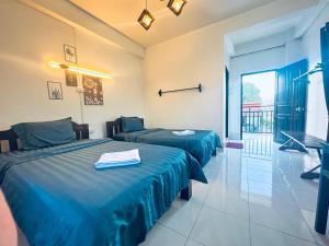 a hotel room with two beds and a balcony at Santara Hostel in Vang Vieng