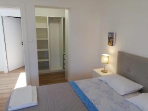 a bedroom with a bed and a lamp and a mirror at Atalaia Garden House in Giz