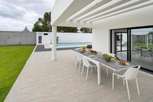 a dining table and chairs on the patio of a house at Bella Casa - piso inferior in Angra do Heroísmo