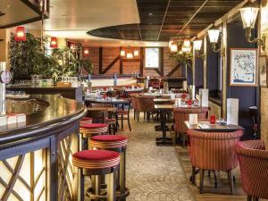 a restaurant with tables and chairs and a bar at ibis Châtellerault in Châtellerault