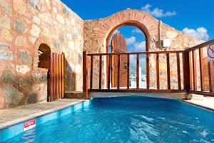 an outdoor pool with a gate and a swimming pool at Elounda Monastiri Cretan sea view house with pool in Epáno Eloúnda