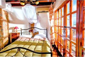 a bedroom with a bed and a large window at Elounda Monastiri Cretan sea view house with pool in Epáno Eloúnda