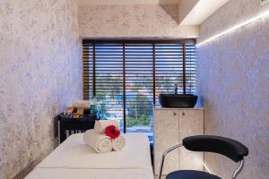 a room with two towels on a bed with a window at Ratan International in Pondicherry
