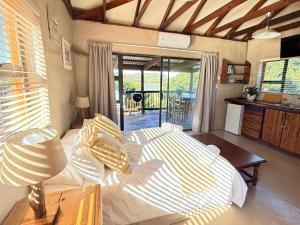 a bedroom with a large bed and a kitchen at East River @ 21 in Kleinemonde
