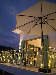 a balcony with an umbrella and lights on it at Half Way Villa in Luang Prabang