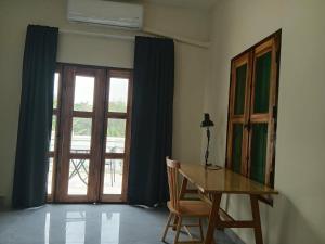 a table and a chair in a room with a window at Half Way Villa in Luang Prabang